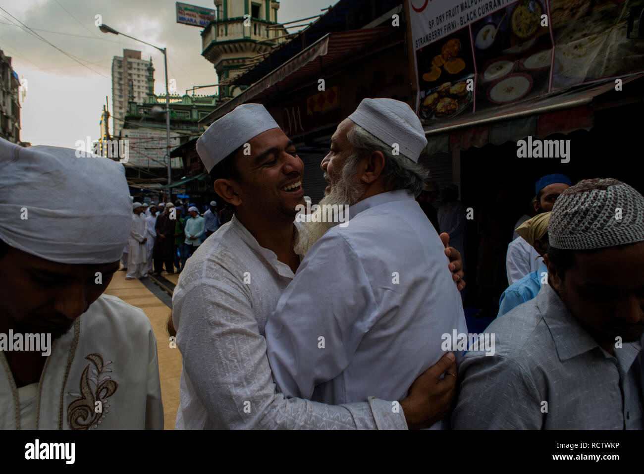 Les hommes musulmans saluent en embrassant après offrant des prières sur l'Eid à Mumbai. Banque D'Images