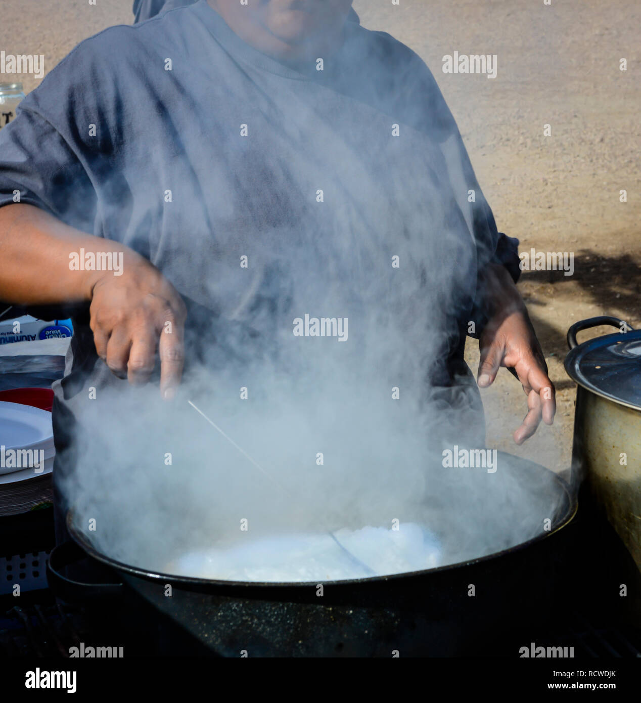 Close up of Native American Woman cooking fry bread dans un chaudron à l'extérieur sur un feu de camp Banque D'Images