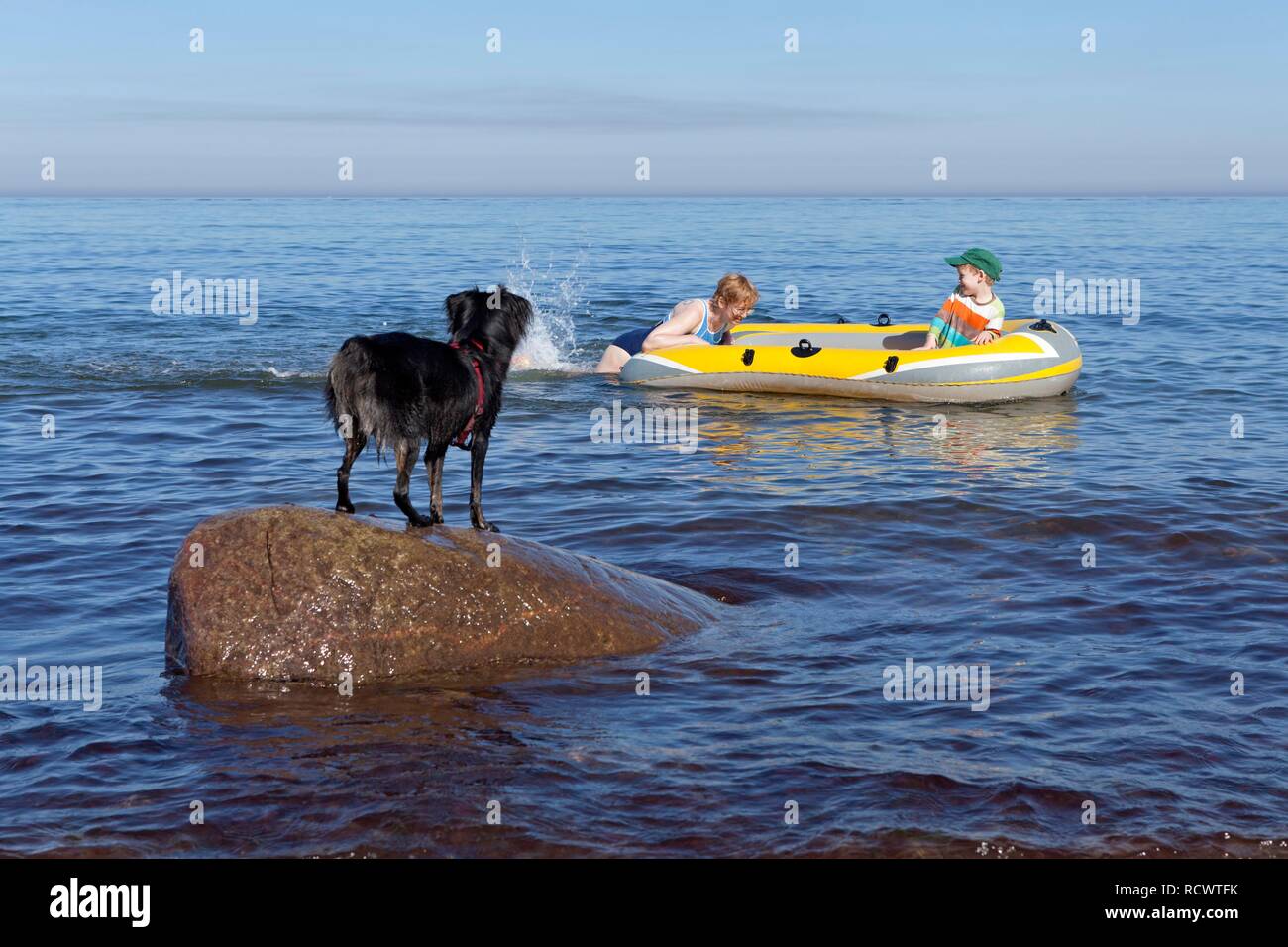 Mère et fils dans un bateau en caoutchouc, chien regardant, Kuehlungsborn-West, Mecklembourg-Poméranie-Occidentale Banque D'Images