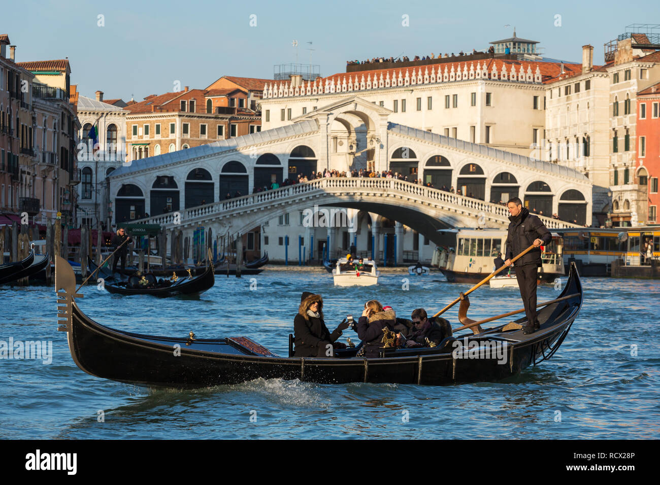 Venise, Italie - 20 mars 2018 : gondolier vénitien équitation les touristes en gondole à Grand Canal avec le pont du Rialto à l'arrière-plan Banque D'Images