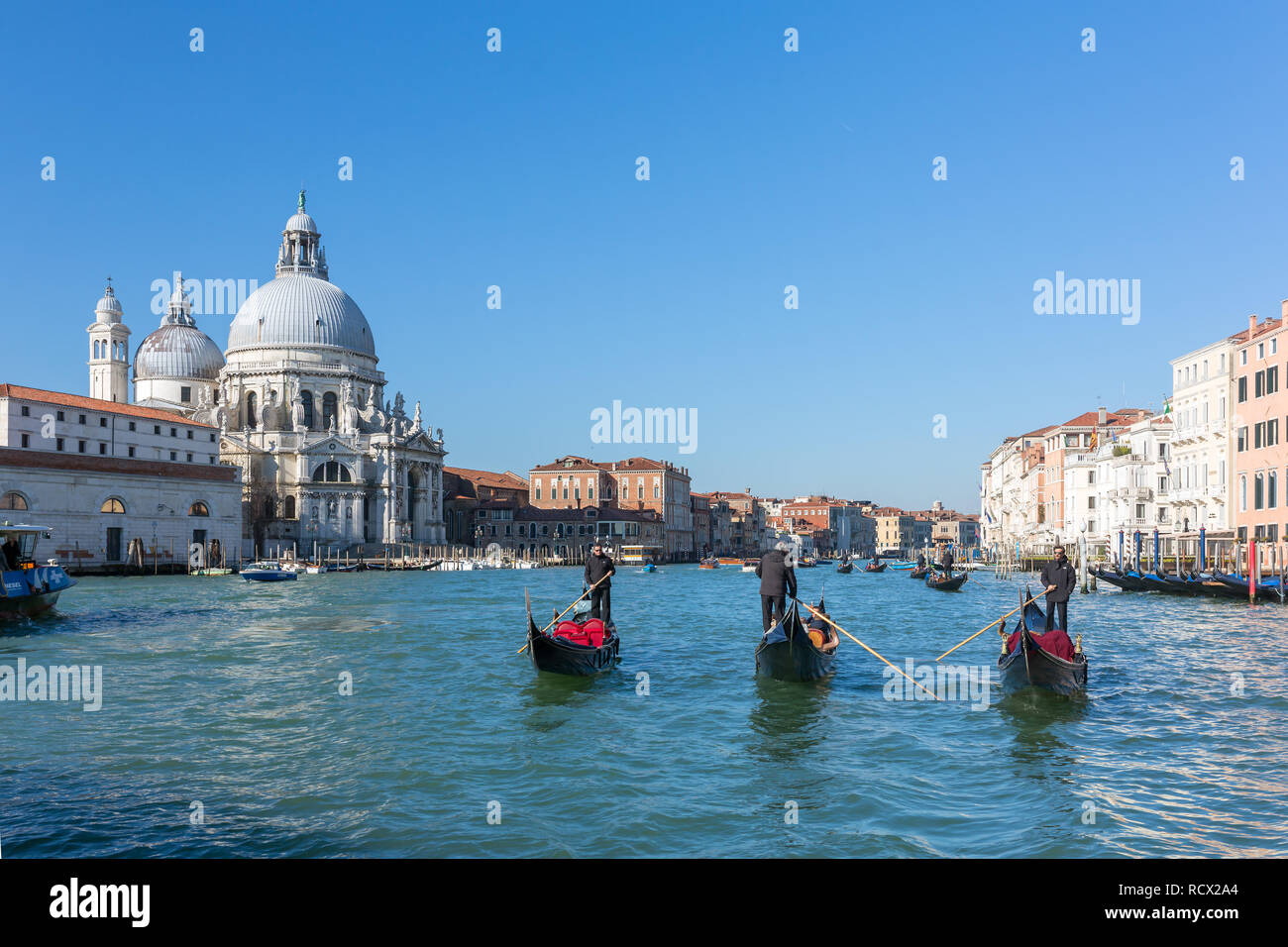 Venise, Italie - 22 mars 2018 : Gondoliers équitation gondoles vénitiennes avec une Santa Maria della Salute à Venise, Italie en arrière-plan Banque D'Images