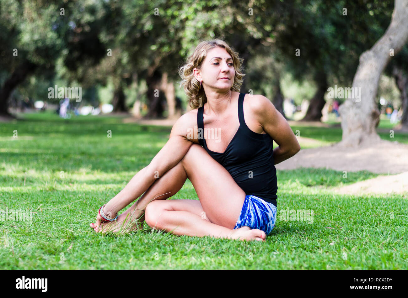 Pretty woman doing yoga exercices dans le parc Banque D'Images