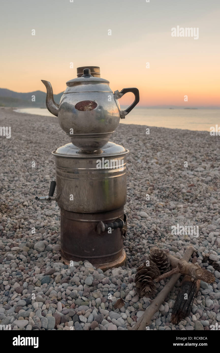 Old fashioned turc pour breewing Samovar thé à la plage de Cirali. Samovar est chauffée par le feu de la combustion du bois. Banque D'Images