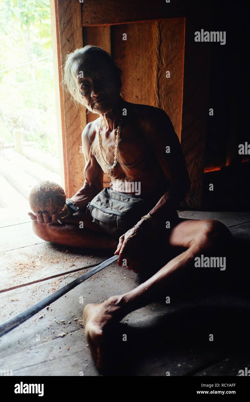 Muara Siberut, îles Mentawai / Indonésie - Aug 15 2017 : membre d'une tribu d'une noix de coco de nettoyage pour la cuisine dans sa jungle accueil Banque D'Images