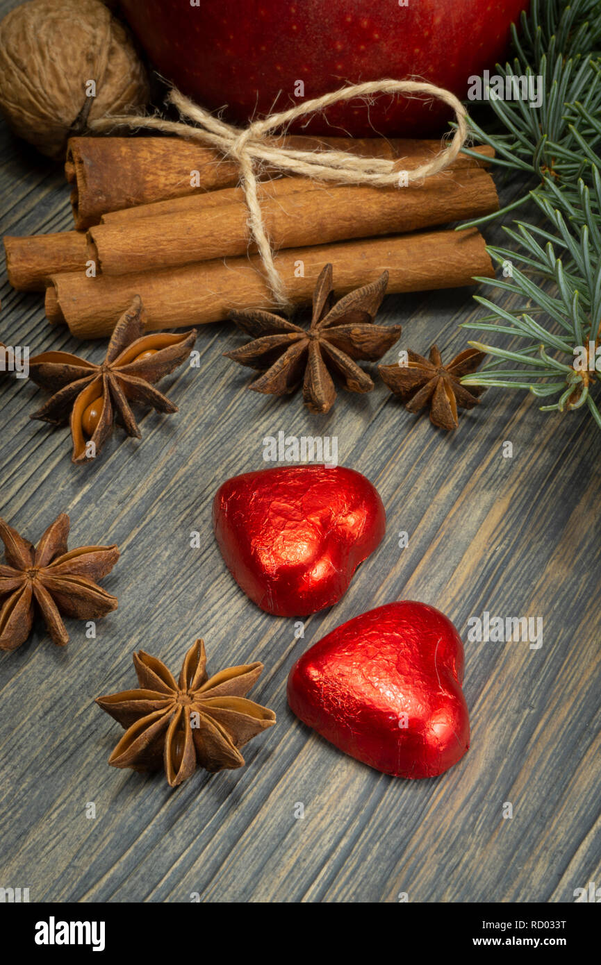 Concept de mise en page de Noël sur fond de bois avec des tas de cannelle anis étoile, pin, feuillage rouge en forme de coeur clémentine et bonbons noix communes Banque D'Images