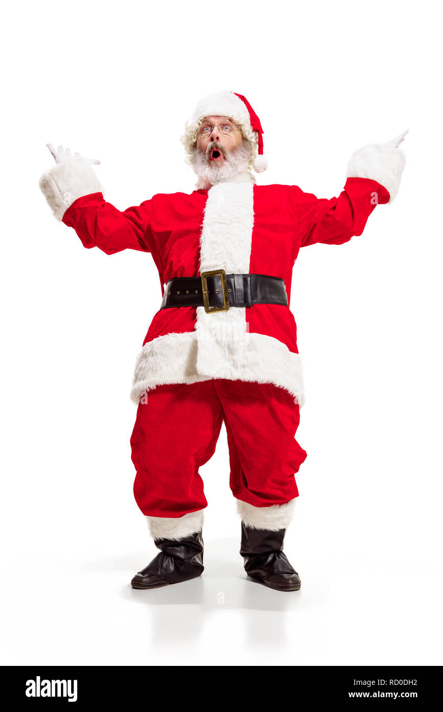Hey, bonjour. Holly jolly x mas noel festif. Longueur totale de funny santa heureux dans la coiffure, costume, ceinture noire, des gants blancs, des vagues avec le bras au studio permanent palm sur fond blanc Banque D'Images
