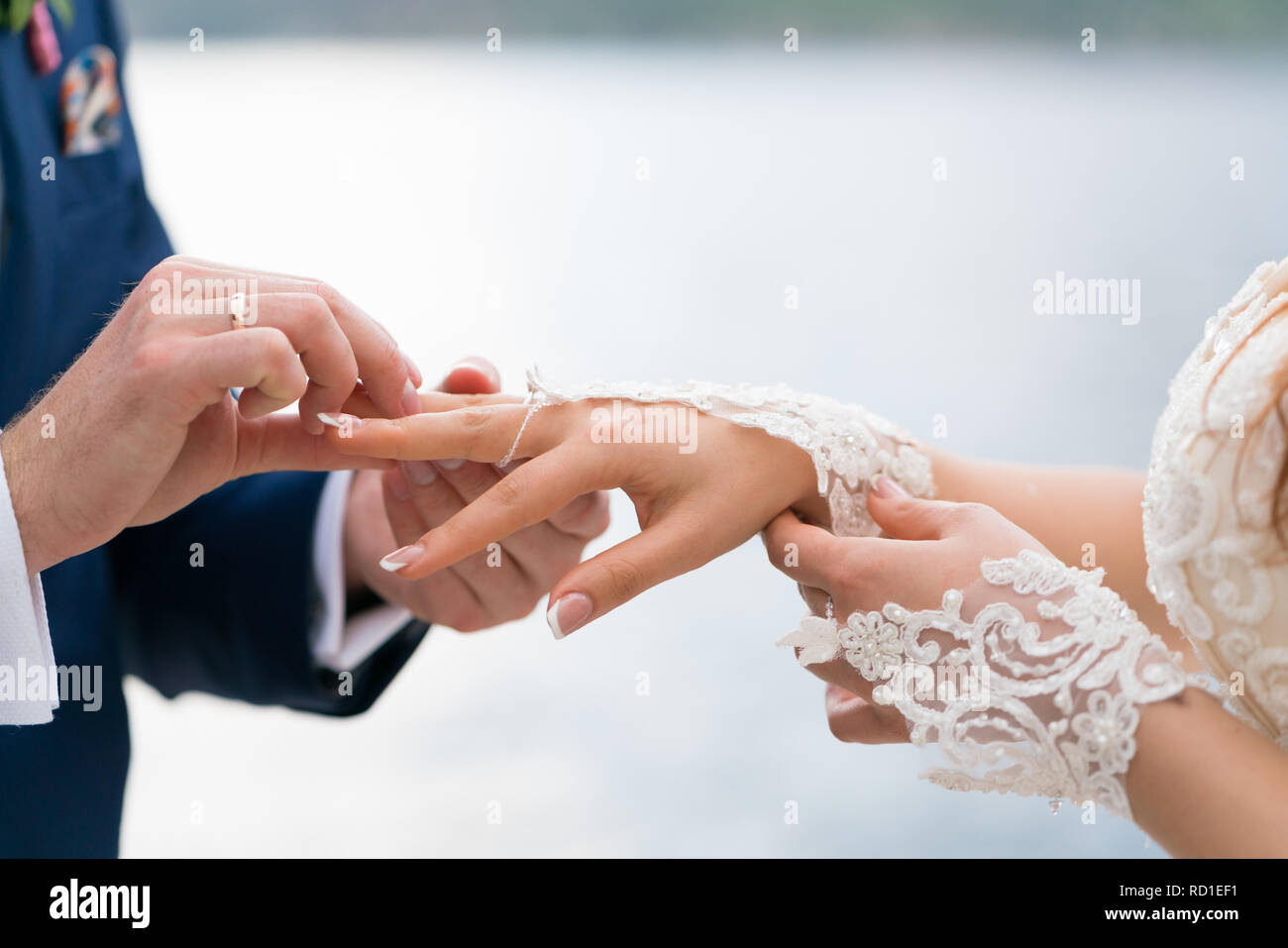Le marié met la bague au doigt de la mariée Photo Stock - Alamy
