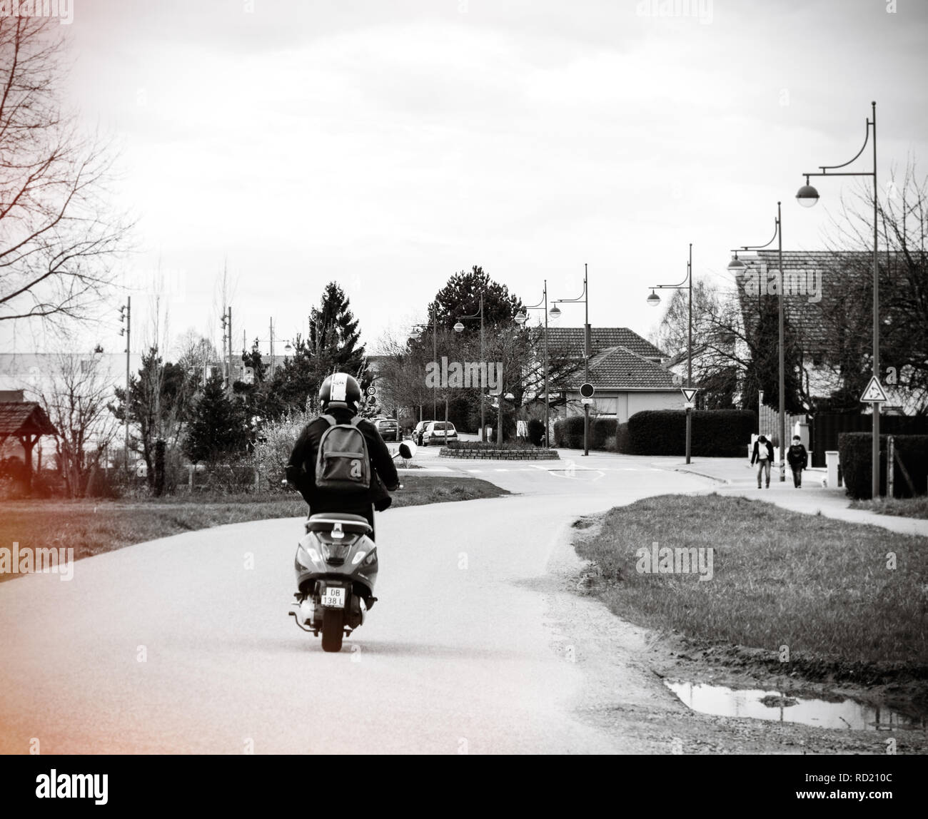 STRASBOURG, FRANCE - Apr 2, 2018 : Jeune femme insouciante italien Vespa Primavera 5 riding scooter rouge sur une route de campagne près de Strasbourg - noir et blanc Banque D'Images