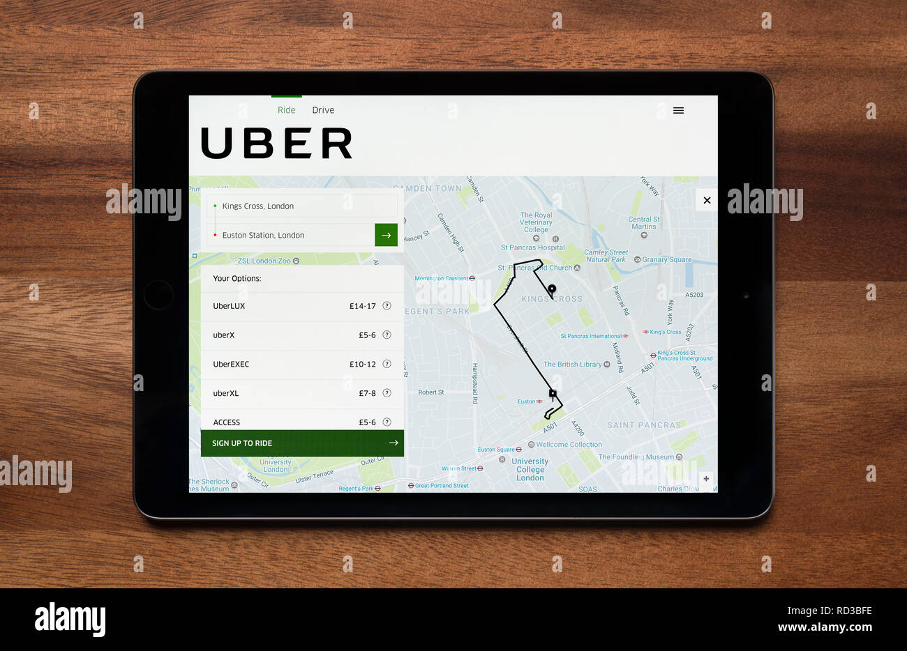 Le site web de Uber est vu sur un iPad tablet, qui repose sur une table en bois (usage éditorial uniquement). Banque D'Images