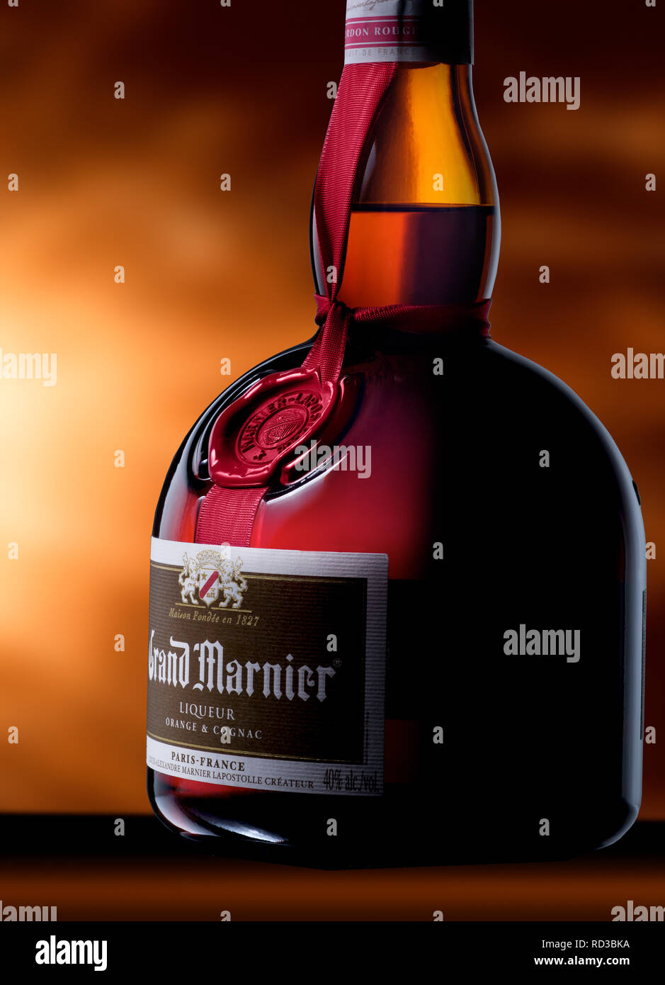 Close up bouteille verre de Grand Marnier cognac, fond orange Banque D'Images