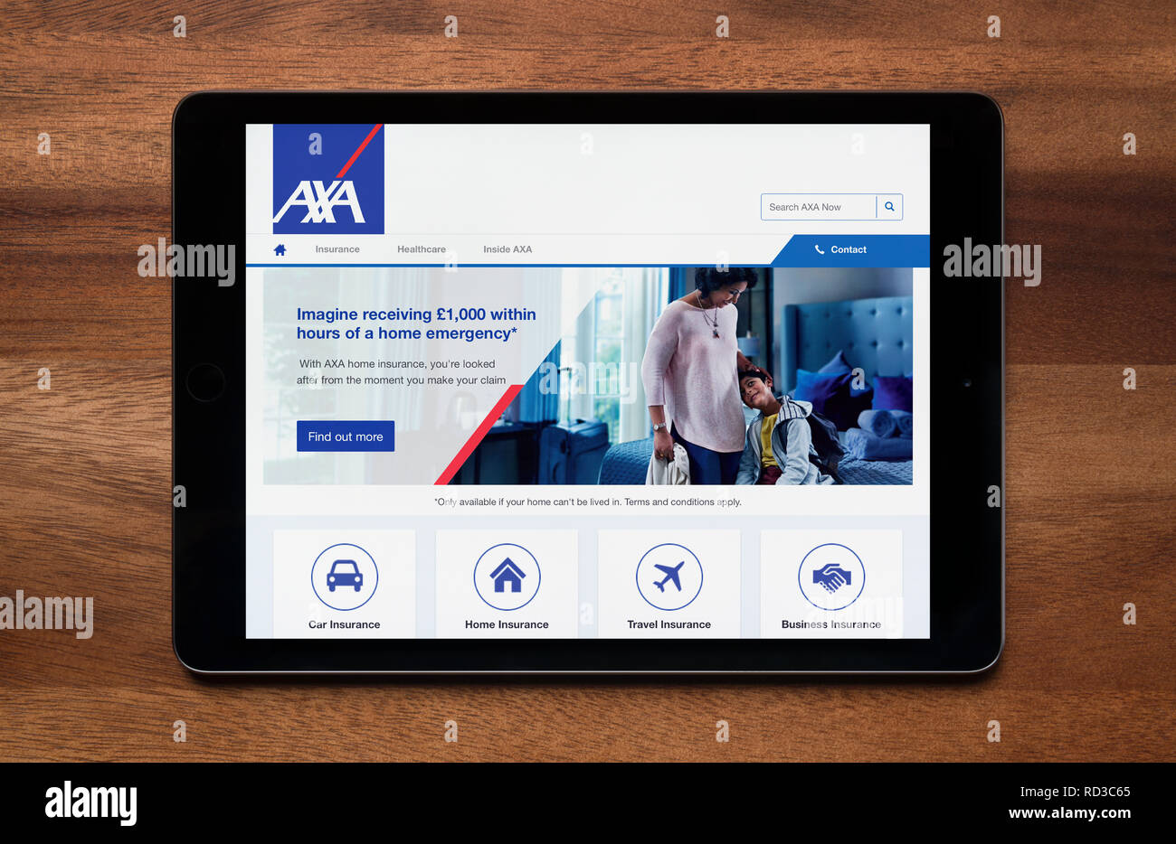 Le site web de l'assurance AXA est vu sur un iPad tablet, qui repose sur une table en bois (usage éditorial uniquement). Banque D'Images