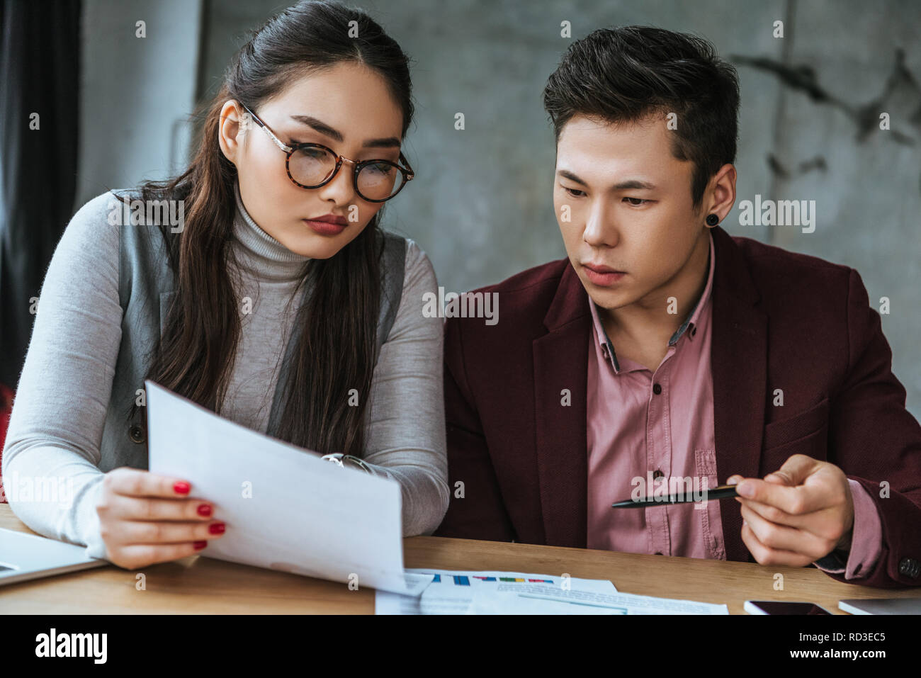 L'accent young asian business colleagues papers in office Banque D'Images