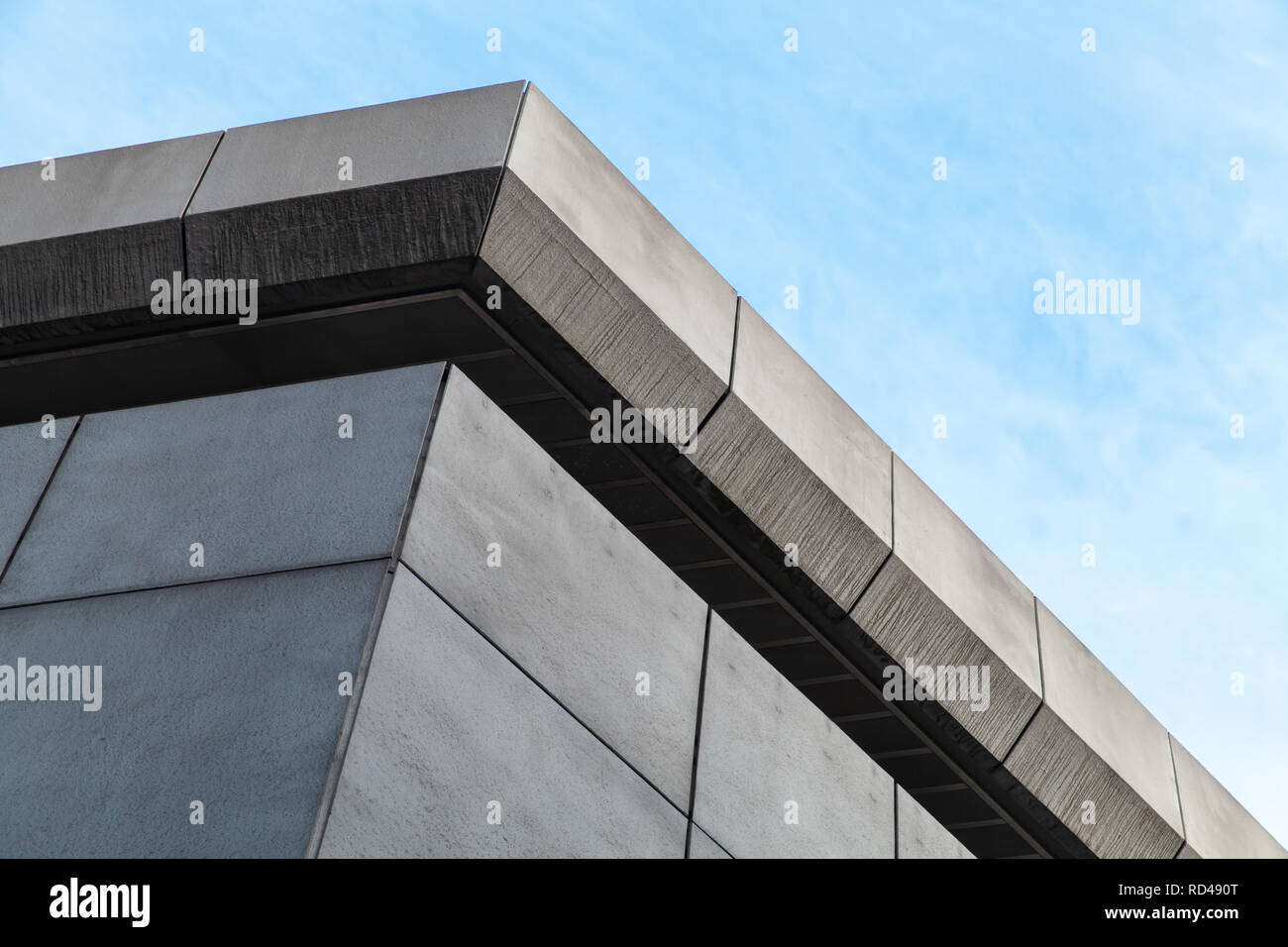Résumé L'architecture contemporaine en pierre grise, fragment d'angle d'un bâtiment industriel under blue sky Banque D'Images