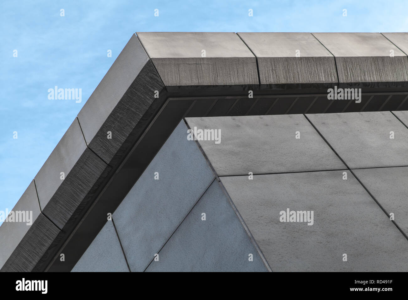 Résumé de l'architecture moderne, fragment d'un bâtiment industriel gris sous ciel bleu Banque D'Images