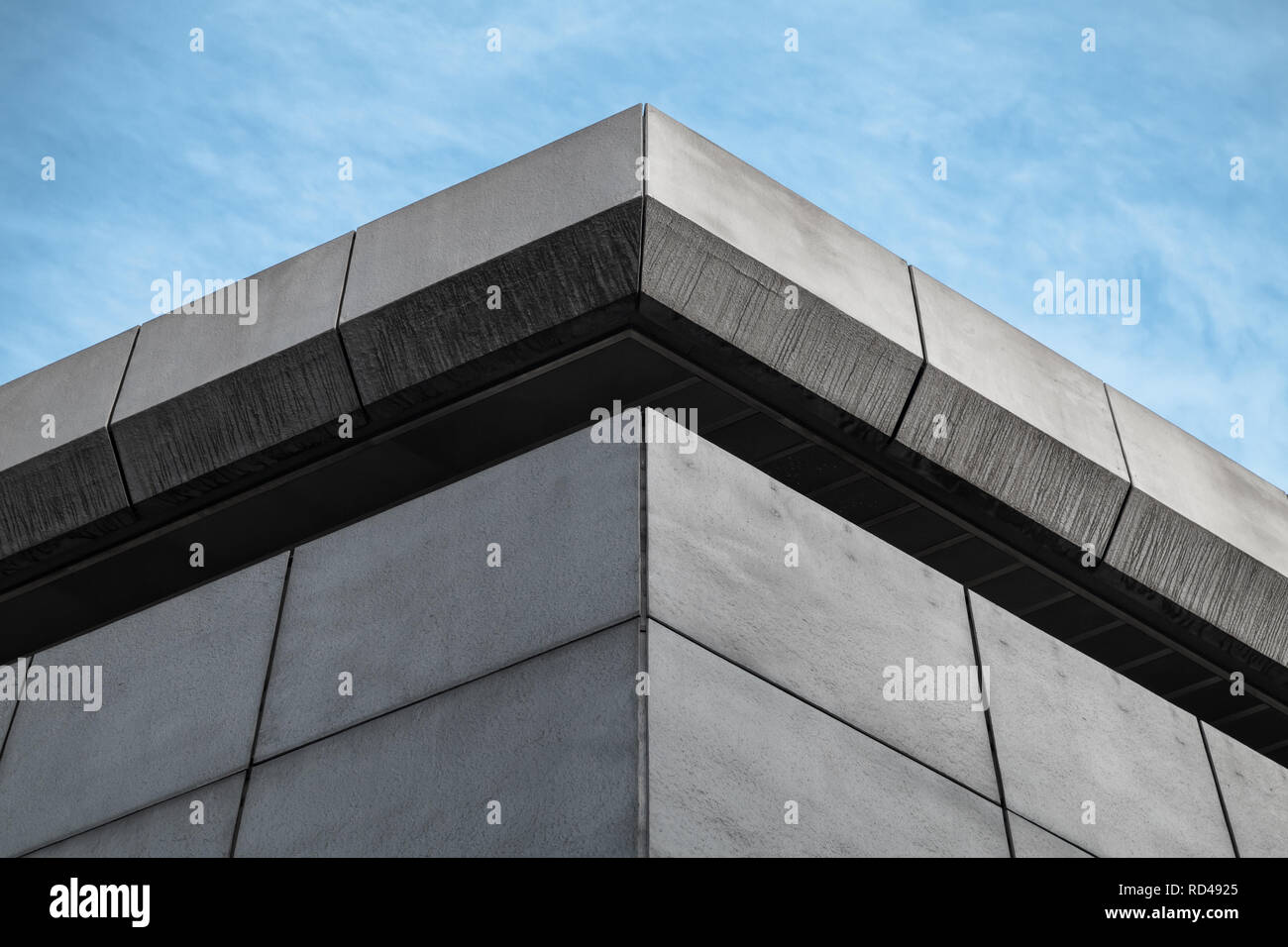 Coin de bâtiment industriel gris sous ciel bleu. Fragment d'architecture contemporaine abstraite Banque D'Images