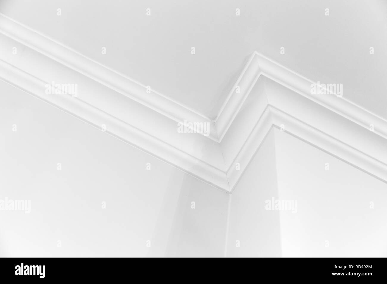 Fragment intérieur blanc avec coin et plinthes de plafond décoratif Banque D'Images