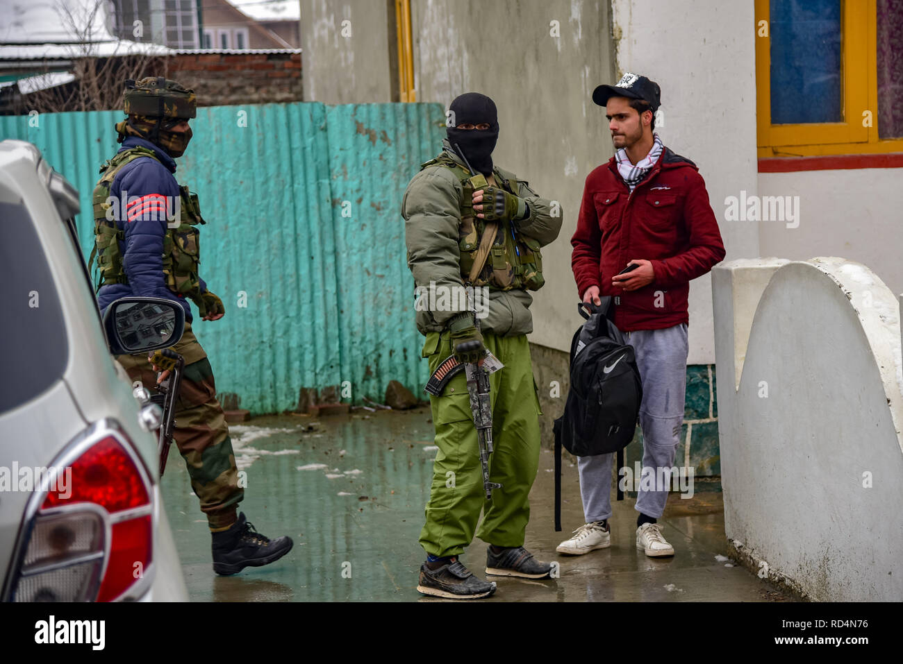 Membre du groupe d'opérations spéciales (GOS) vu l'interrogatoire d'un étudiant au cours de l'opération de recherche à Srinagar. Selon la police, au moins cinq membres des forces gouvernementales ont été blessés jeudi dans l'explosion d'une grenade imputée à des rebelles qui combattent contre la règle des Indiens dans la ville principale du Cachemire contrôlé. Banque D'Images