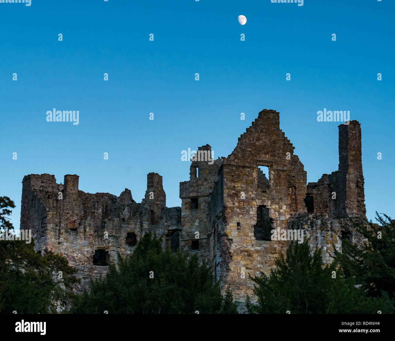 Château de Dirleton, East Lothian, Ecosse, Royaume-Uni, 17 janvier 2019. Météo France : un ciel clair au coucher du soleil sur les ruines du château médiéval. Une lune croissante est lumineux dans le ciel sans nuages Banque D'Images