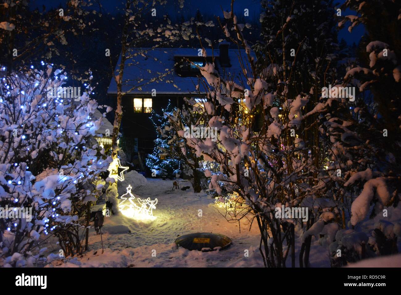 Petite maison couverte de neige et de feux d'chtistmas dans le pittoresque Bad Goisern, Hallstatt. L'Autriche. La tombée de la vue. Banque D'Images