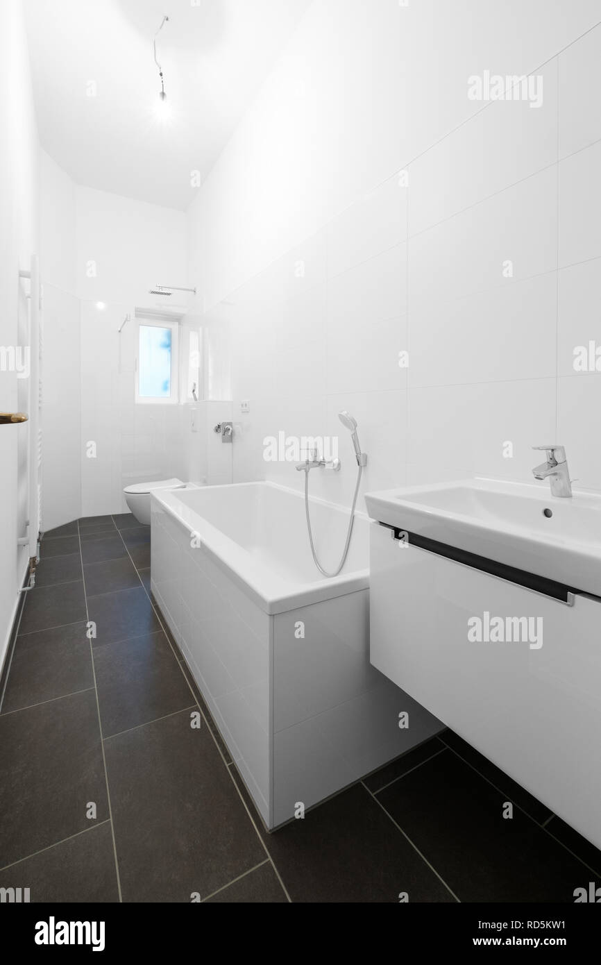 White salle de bains avec baignoire et douche après rénovation - Banque D'Images
