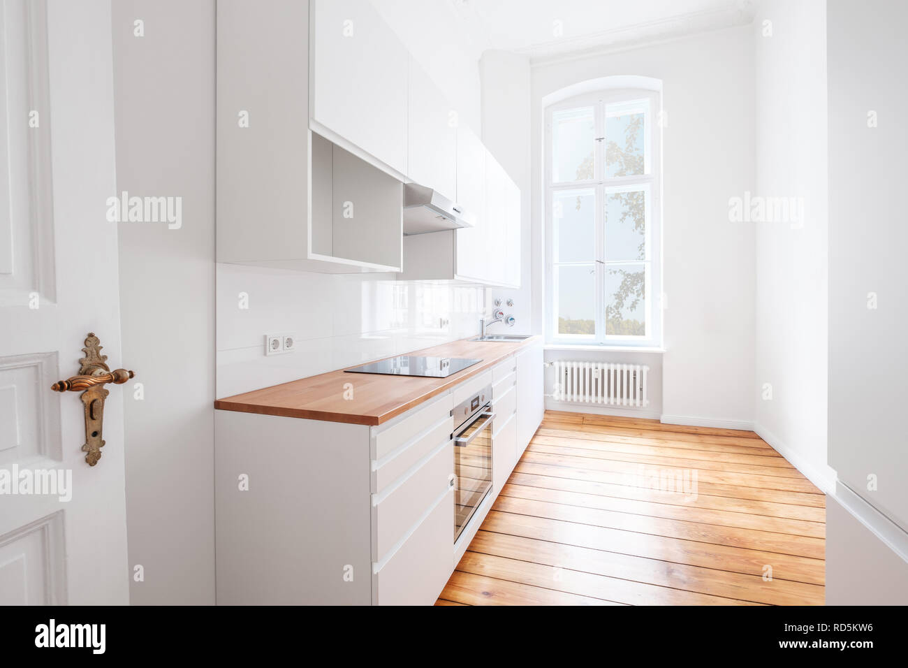 Vide, nouvelle cuisine avec un mobilier blanc et de sol en bois - Banque D'Images