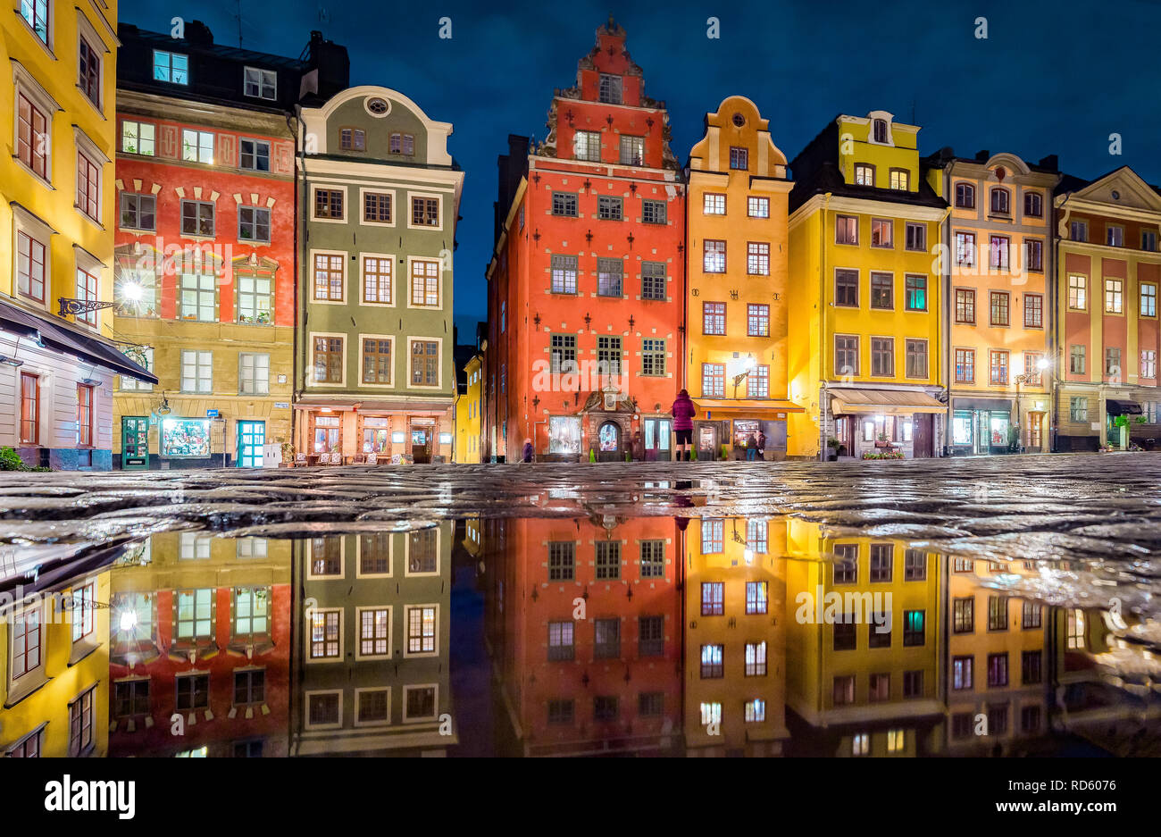 L'affichage classique de maisons colorées à la place Stortorget célèbre dans le quartier historique de Stockholm, Gamla Stan (vieille ville) se reflétant dans une flaque d'eau la nuit, centra Banque D'Images