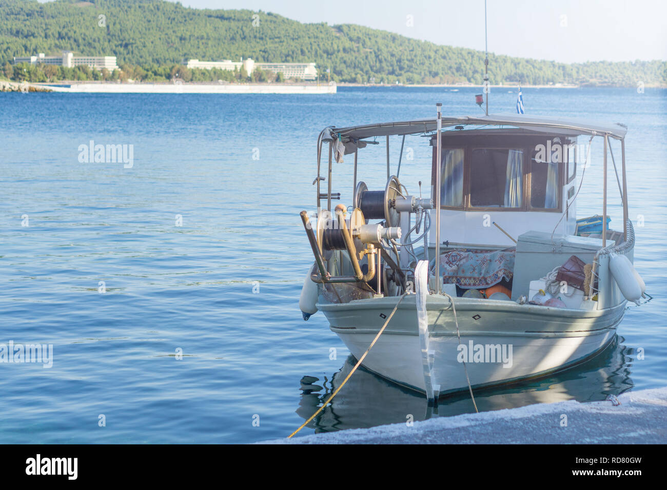 Petit bateau de pêche surchargé blanc à côté du quai. Banque D'Images