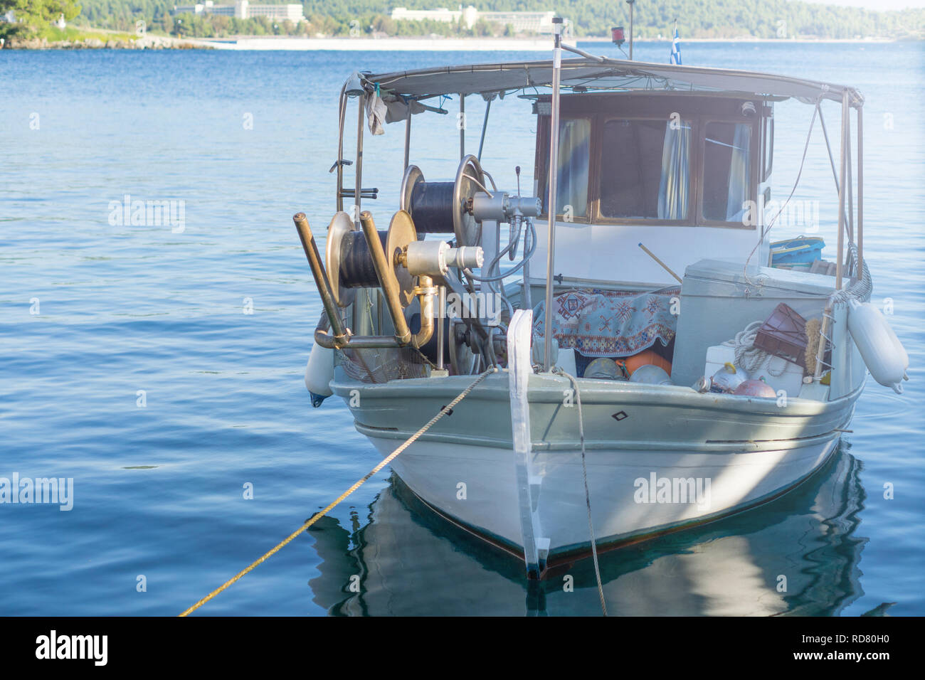 Petit bateau de pêche surchargé blanc à côté du quai. Banque D'Images