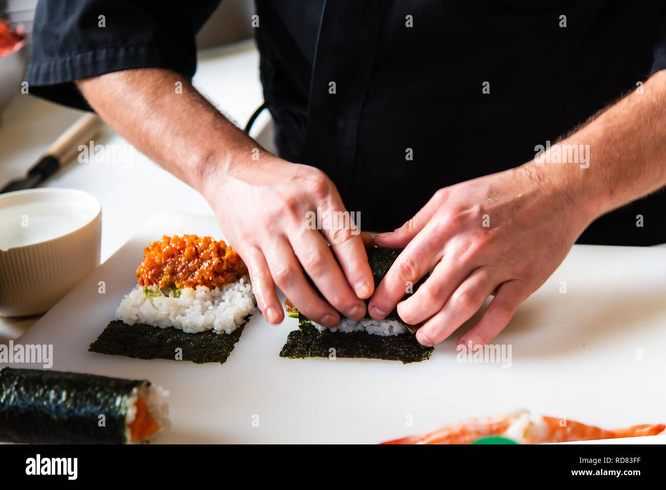 Chef making rouleaux de sushi au bar close up Banque D'Images