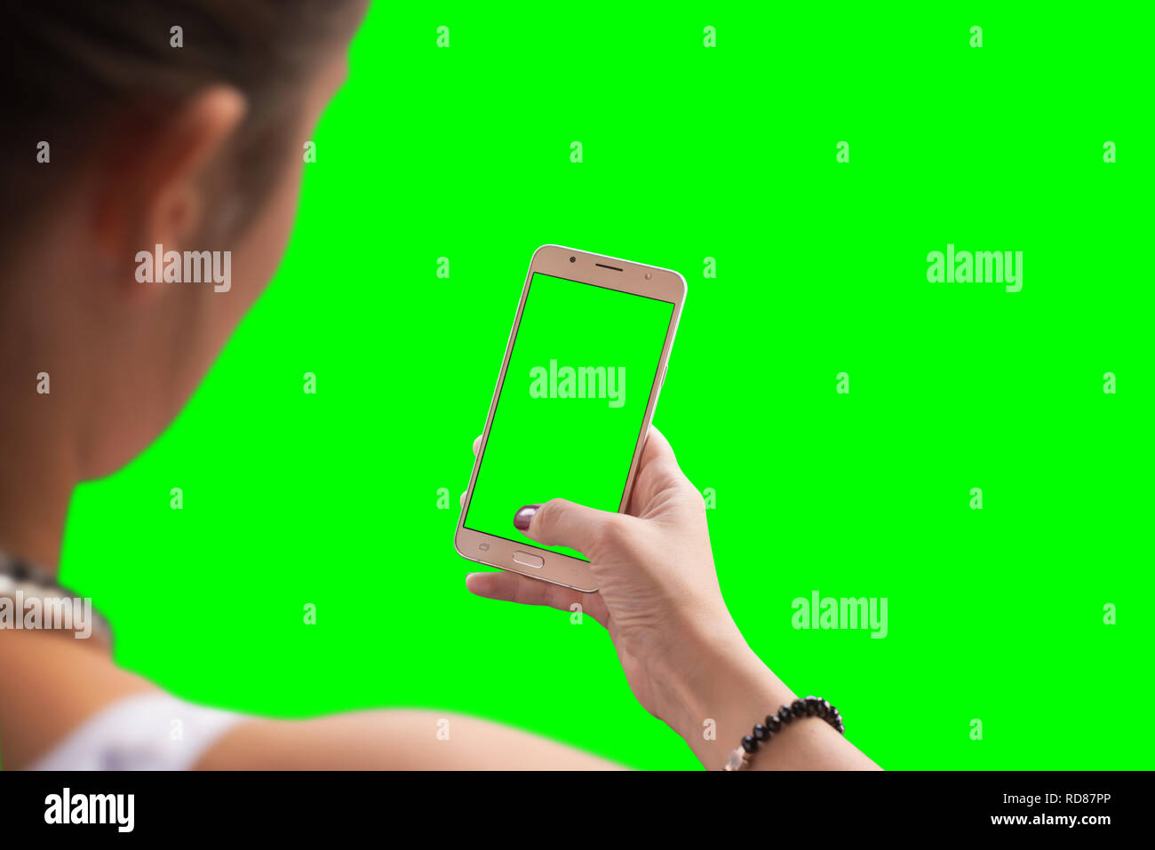 Girl Utilisez smart phone. Écran isolé et l'arrière-plan en vert pour une maquette. Banque D'Images