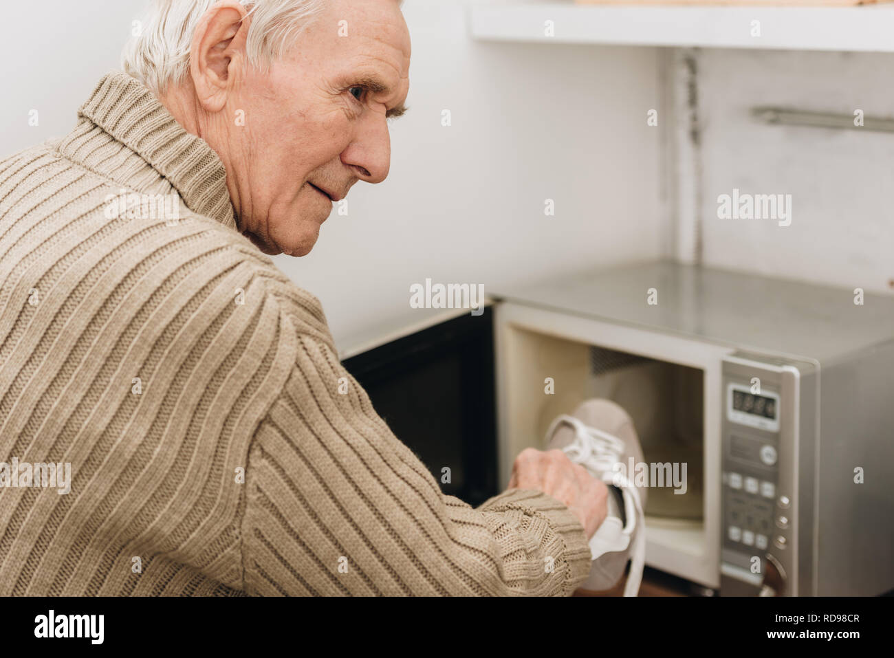 La maladie d'Alzheimer senior chaussure mettre au micro-ondes Photo Stock -  Alamy