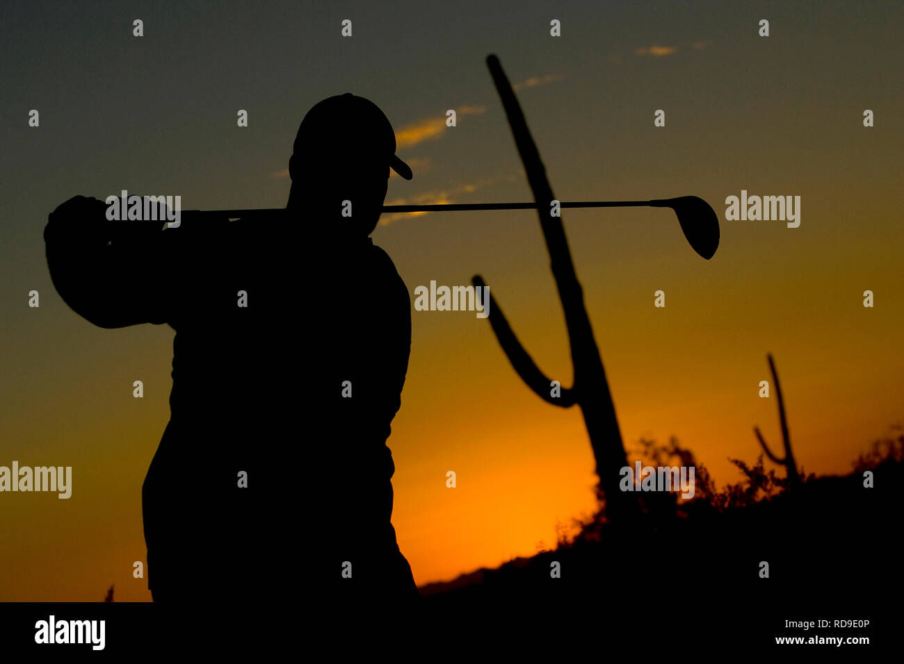 La silhouette d'un golfeur à la fin de sa course pendant le coucher du soleil à Phoenix, Arizona. Banque D'Images