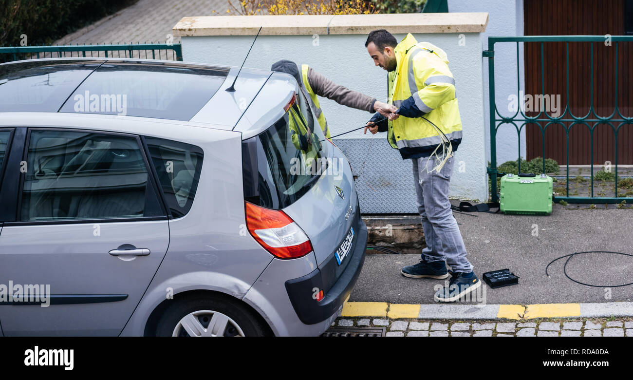 PARIS, FRANCE - MAR 19, 2018 : l'équipe travaillant à proximité d'égouts ouvert trou trou avec le câble sur la bobine spool - télécommunication fournisseur d'accès internet société travaillant sur la mise en œuvre de câbles à fibres optiques Banque D'Images