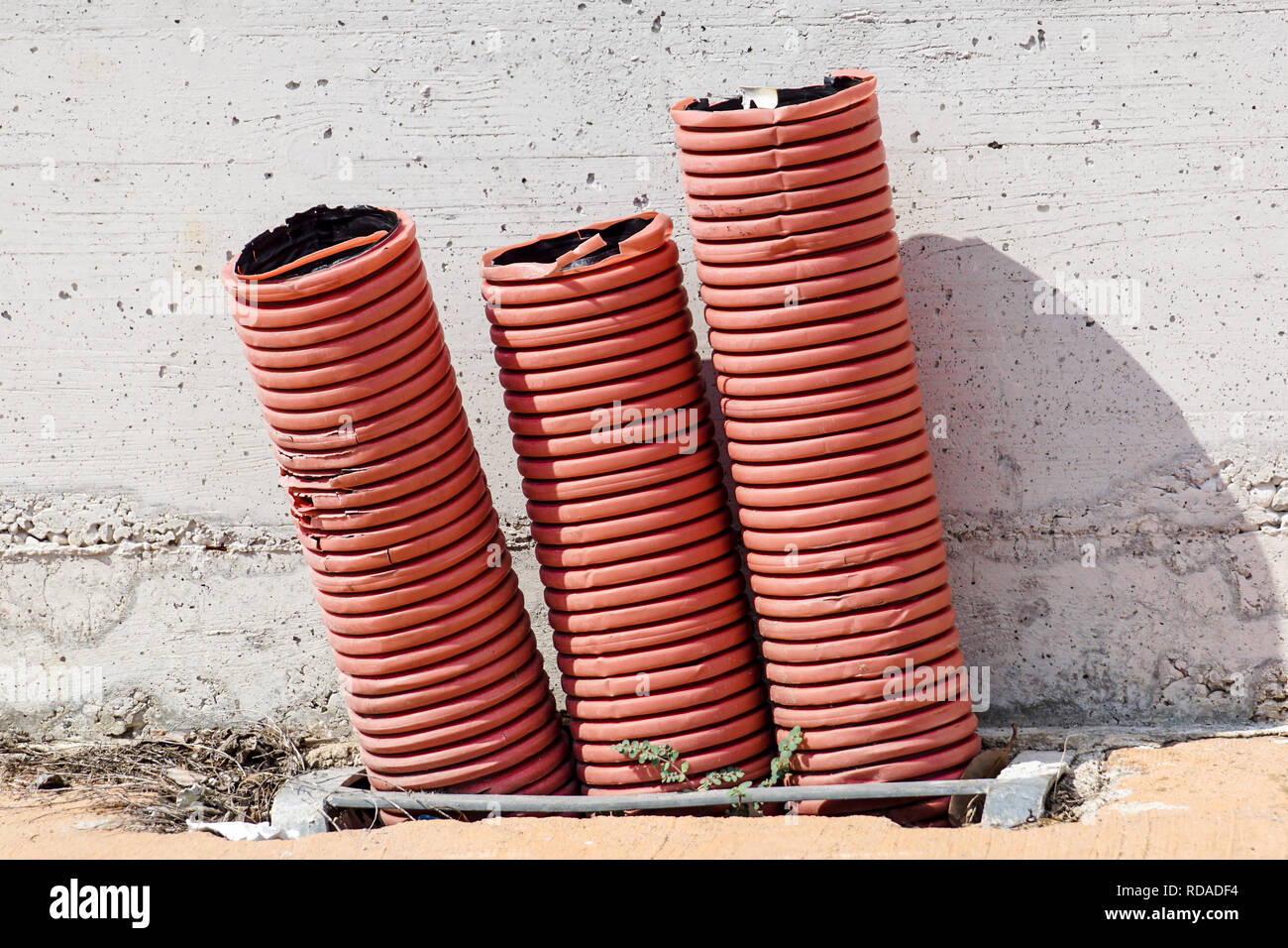 Orange Rouge gaine ondulée pour câbles électriques, sur un chantier de construction Banque D'Images