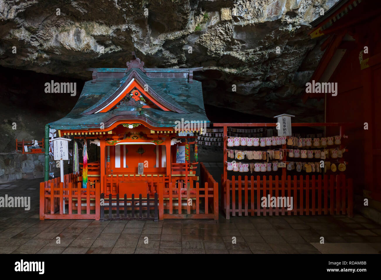 Miyazaki, Japon - 6 novembre, 2018 : Le sanctuaire Udo peint de couleurs vives, est situé dans une grotte à flanc de falaise avec ema lapin à côté Banque D'Images
