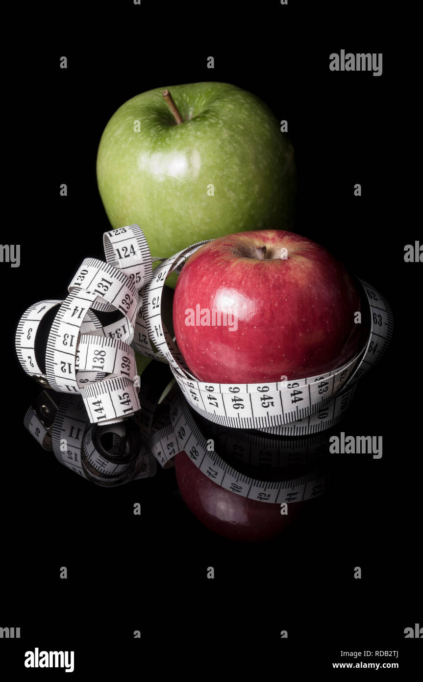 La pomme verte et rouge entourée de ruban de mesure sur noir avec reflet  Photo Stock - Alamy