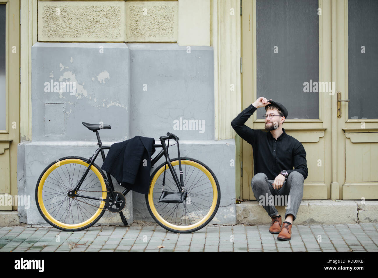 L'homme d'affaires assis sur le plancher avec location.bel homme appréciant city ride en vélo. Banque D'Images