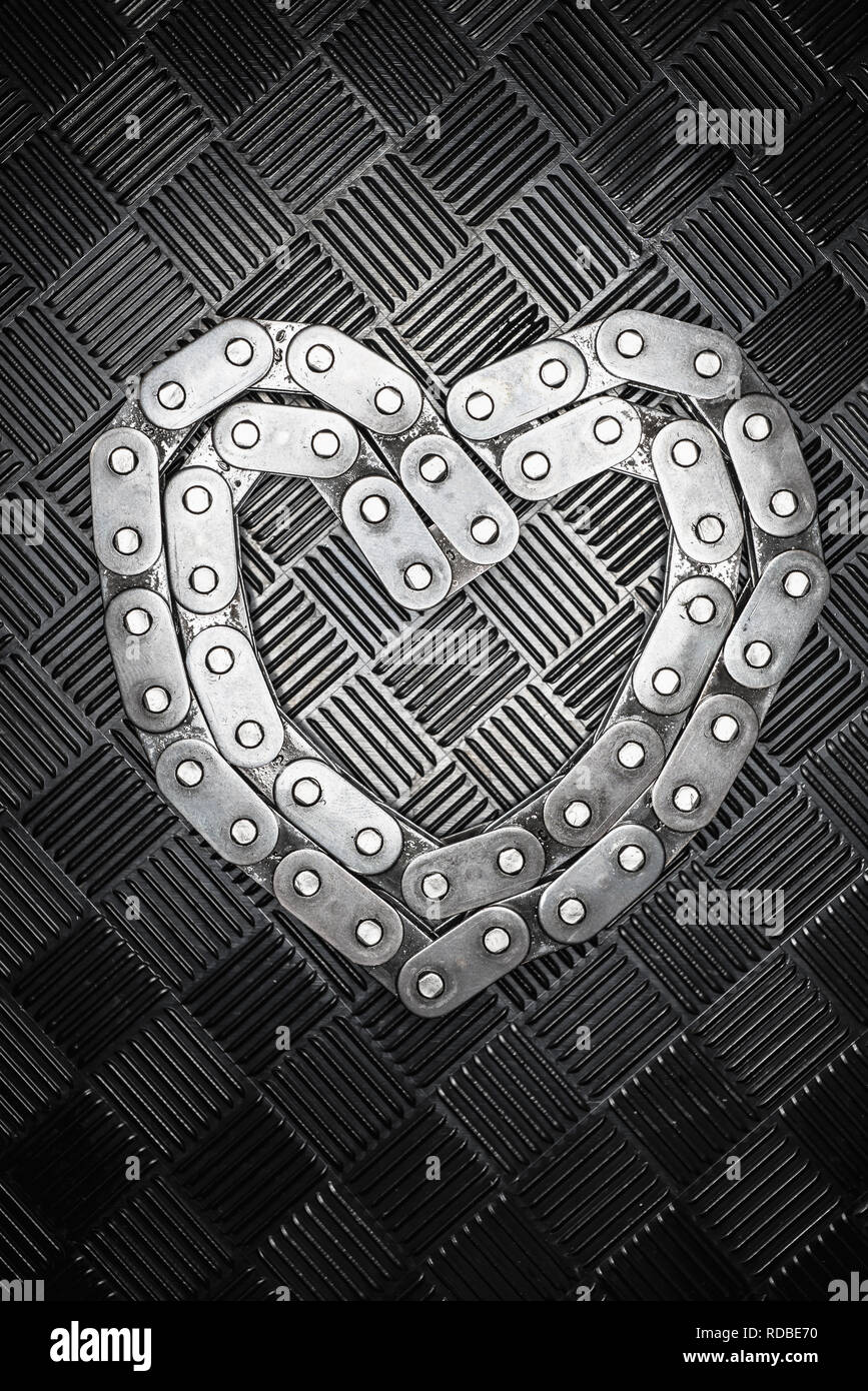 Le coeur en métal à partir de la chaîne avec une combinaison love heart sur le fond métallique. Concept pour la Saint-Valentin Banque D'Images