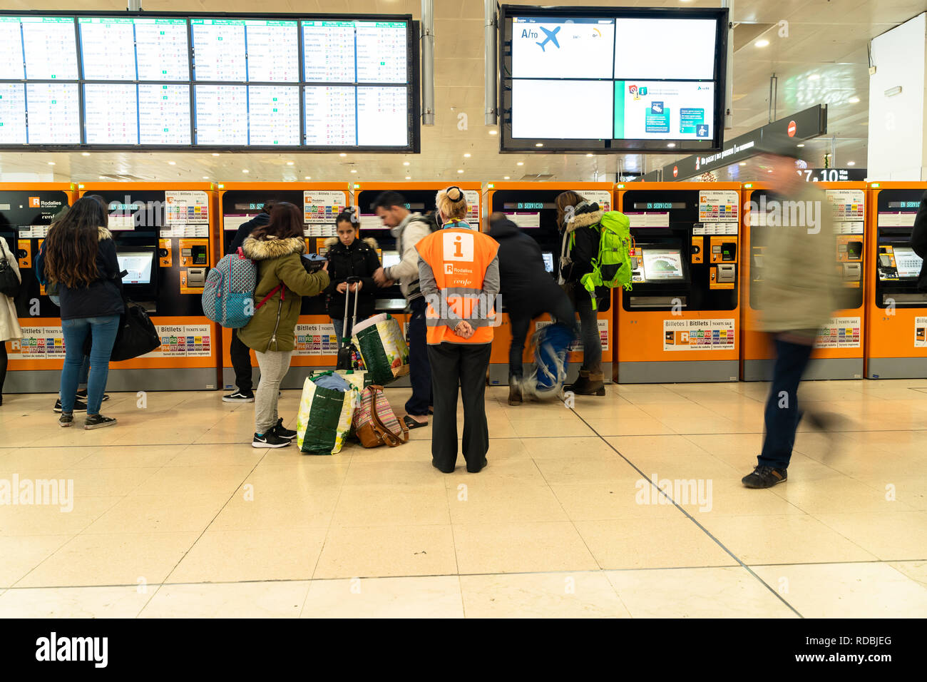 Renfe de l'hôte d'aider les voyageurs à acheter des billets dans les distributeurs automatiques de la gare Sants de Barcelone, de l'information rodalies Catalogne, Espagne Banque D'Images