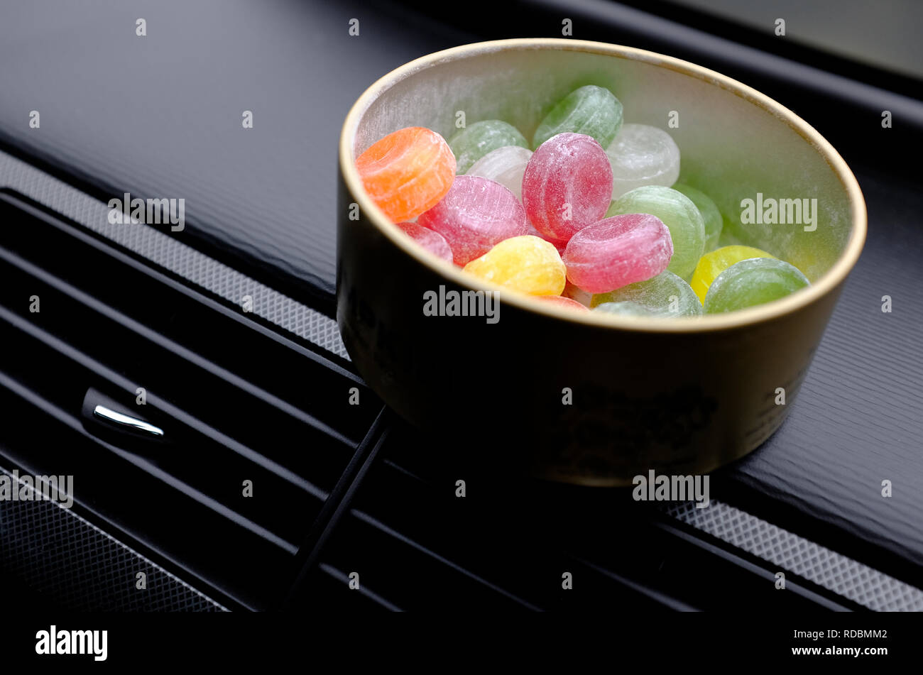 Les bonbons dans boite métal ronde sur le tableau de bord de voiture Banque D'Images