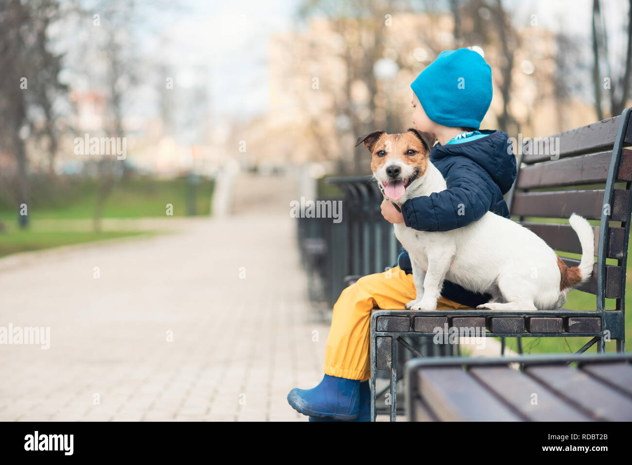 Concept d'animaux domestiques avec boy hugging son chien de compagnie dans spring park Banque D'Images