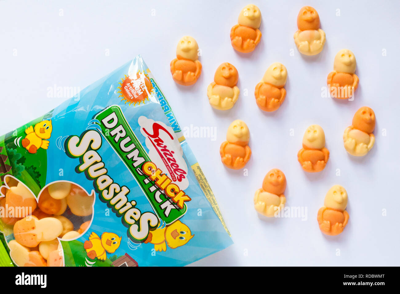Sac d'Drumchick Swizzels Squashies, orange & saveur ananas gencives ouvert avec table des matières déversées ensemble renversé sur fond blanc - prêt pour Pâques Banque D'Images