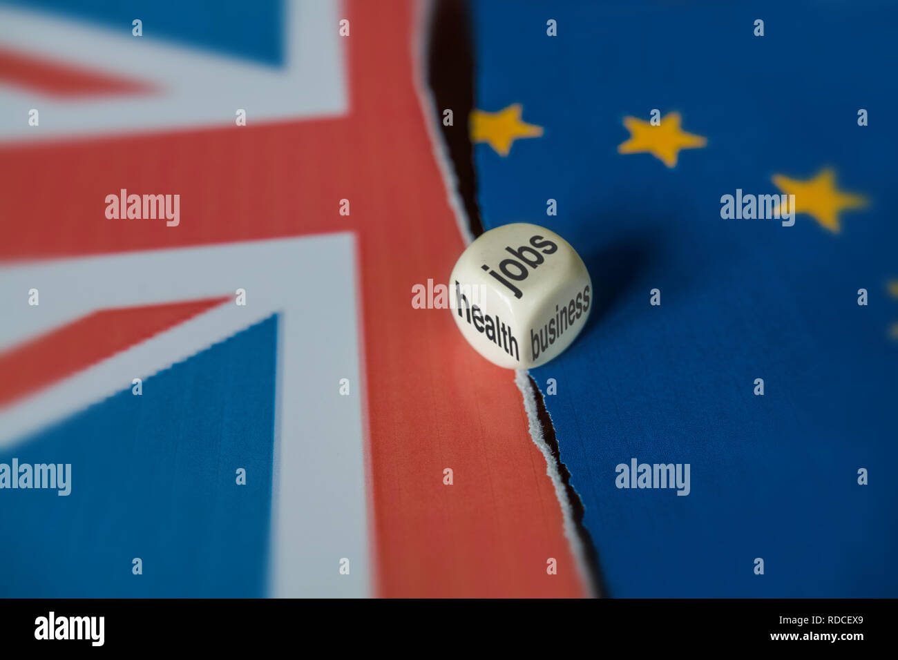 Un premier montage entre le Royaume-Uni et symboles de l'UE. Sur la surface, entre les deux drapeaux il y a un dé qui affiche trois côtés : l'emploi, de santé et d'affaires. Banque D'Images