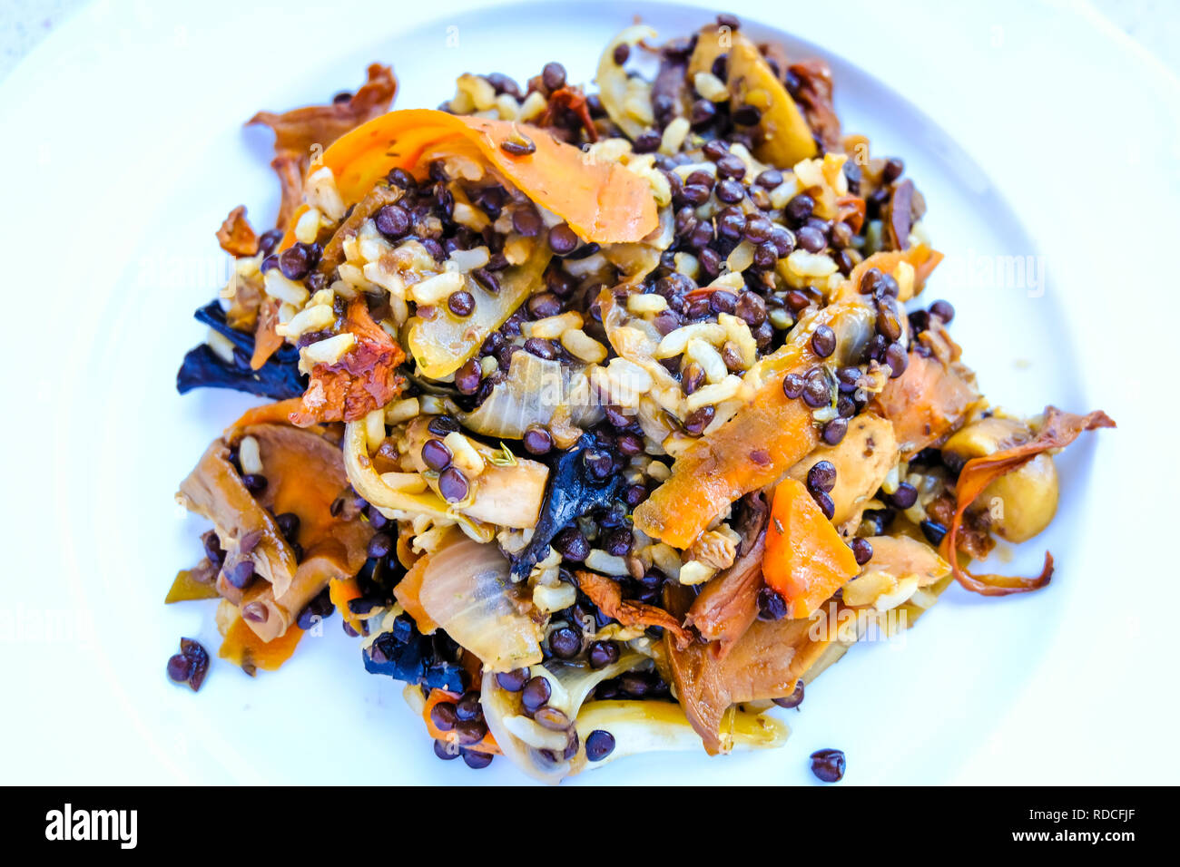 Lentilles Beluga avec du riz brun et de champignons. Recette macrobiotique. Banque D'Images