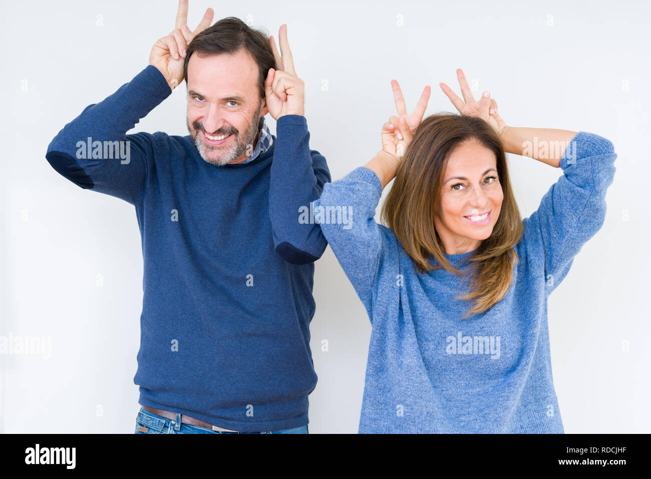 Beau Couple D Age Moyen De L Amour Sur Fond D Humour Et D Isoles Qui Fou Avec Les Doigts Sur Les Oreilles De Lapin En Tete Souriant De Bonne Humeur Photo Stock Alamy