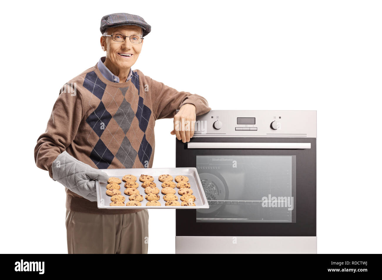 Vieil homme tenant un plateau avec des biscuits et s'appuyant sur un four isolé sur fond blanc Banque D'Images