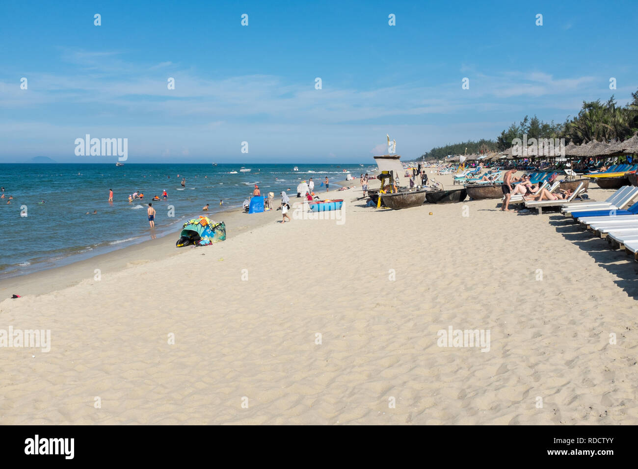 Petits bateaux de pêche ou de coracles sur la plage avec chaises longues dans la ville de Hoi An à Quang Nam Province Banque D'Images