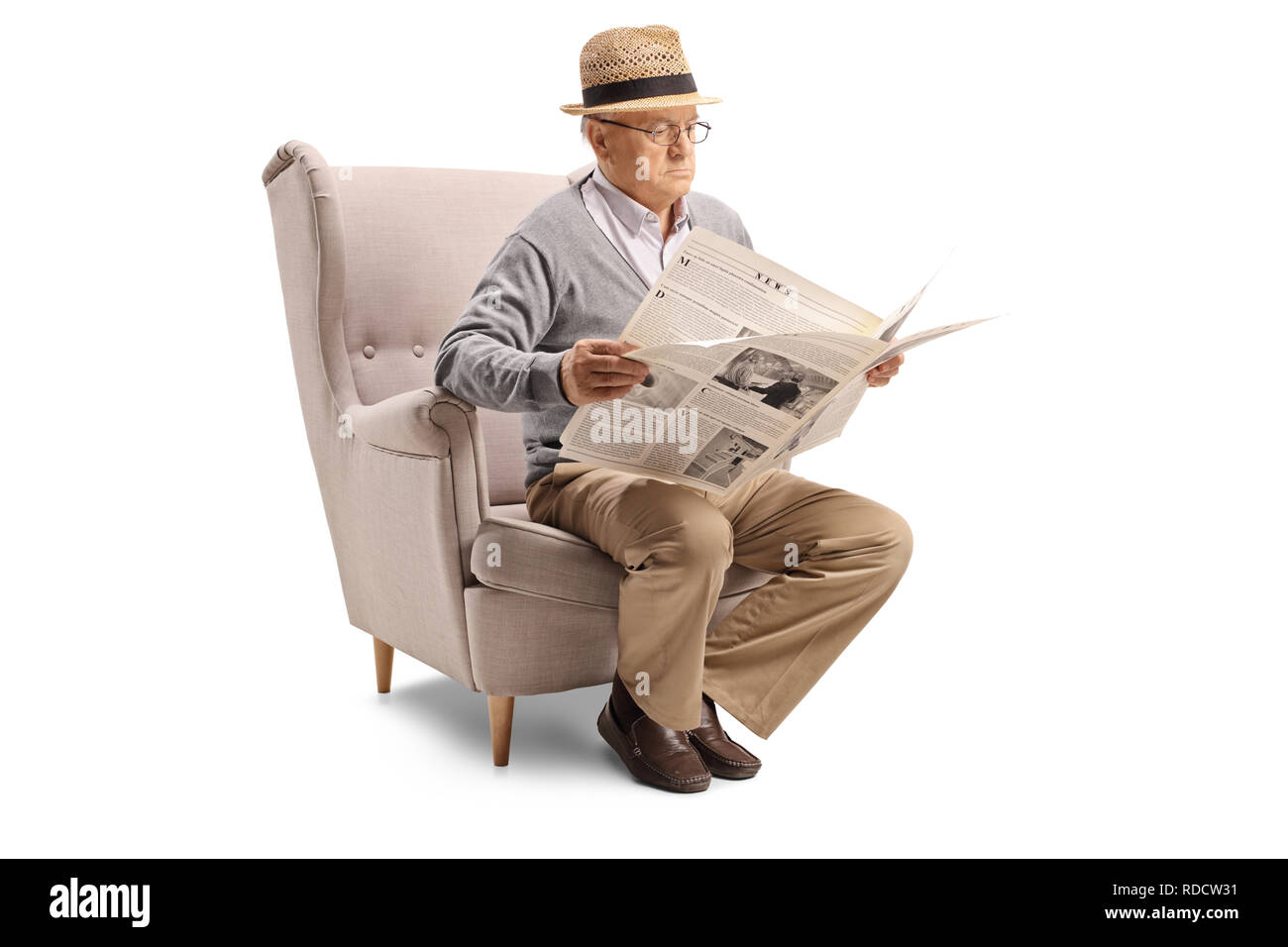 Hauts homme assis dans un fauteuil et lit un journal isolé sur fond blanc Banque D'Images