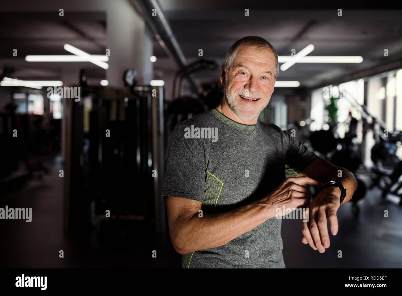 Un homme de sport cheerful senior dans la mesure du temps tout en faisant de l'exercice. Copier l'espace. Banque D'Images