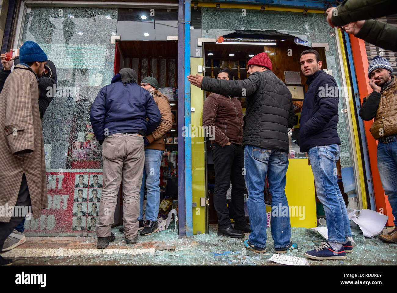 Les hommes du cachemire vu debout à côté de la casse de lunettes boutiques suite à l'explosion à Srinagar. Une grenade lancés des militants sur une partie de la police dans la ville de Srinagar, endommageant quelques magasins à proximité mais il n'y a pas eu de rapports d'accident, a annoncé la police. Cet attentat intervient moins de 10 jours avant la fête de la République. La sécurité dans la vallée du Cachemire a été augmenté avant le 70e jour de la République de l'Inde. Banque D'Images